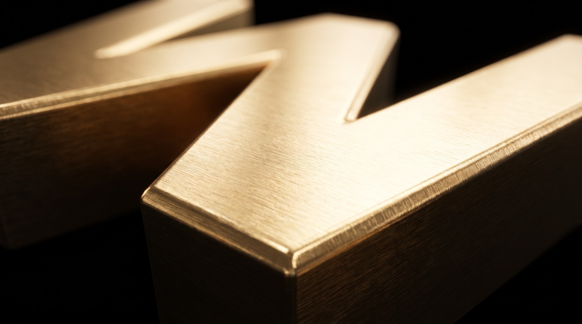 Extreme close-up of the brushed gold surface and beveled edge of the Walletz W.